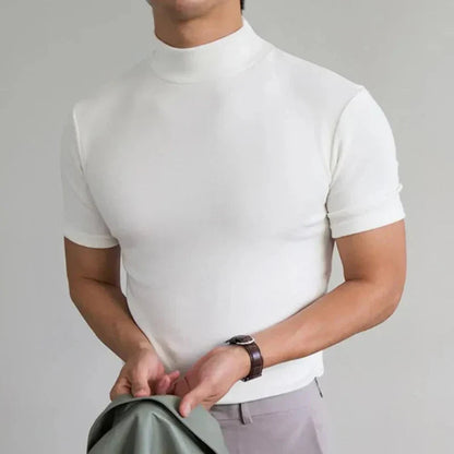 Model wearing the top in white with light trousers, a brown leather-strap watch and a green jacket in hand 4