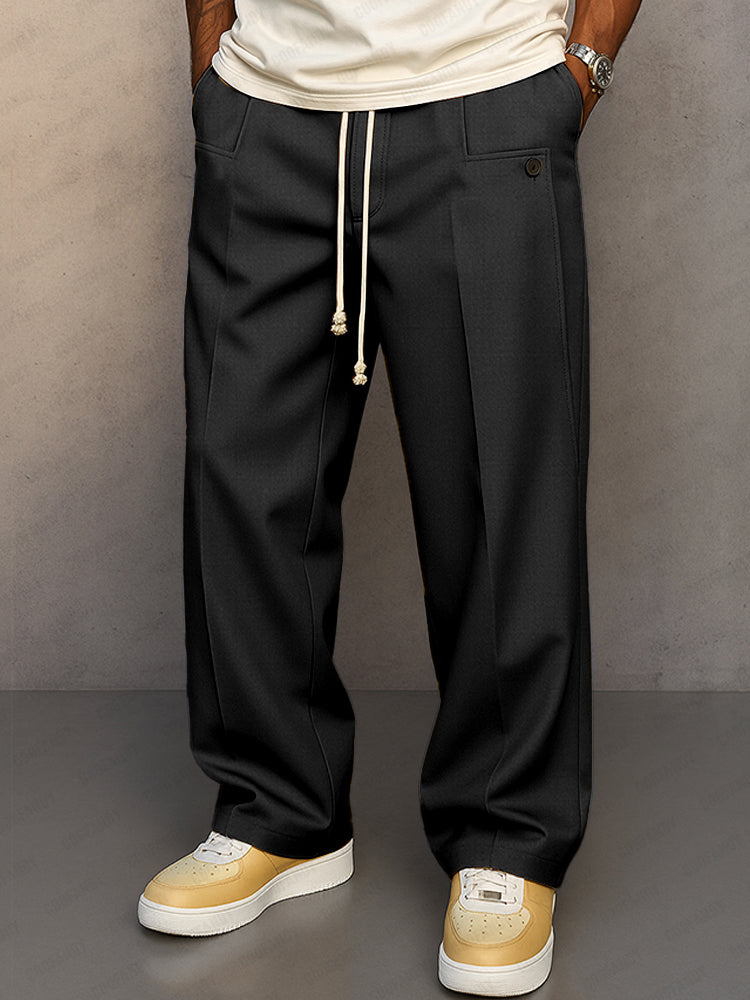 Front view of the wide-leg drawstring trousers in black, with cream cord, button pocket tab and pressed front crease. 2