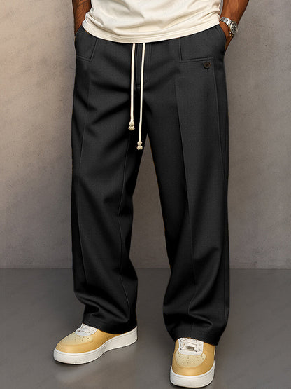 Front view of the wide-leg drawstring trousers in black, with cream cord, button pocket tab and pressed front crease. 2