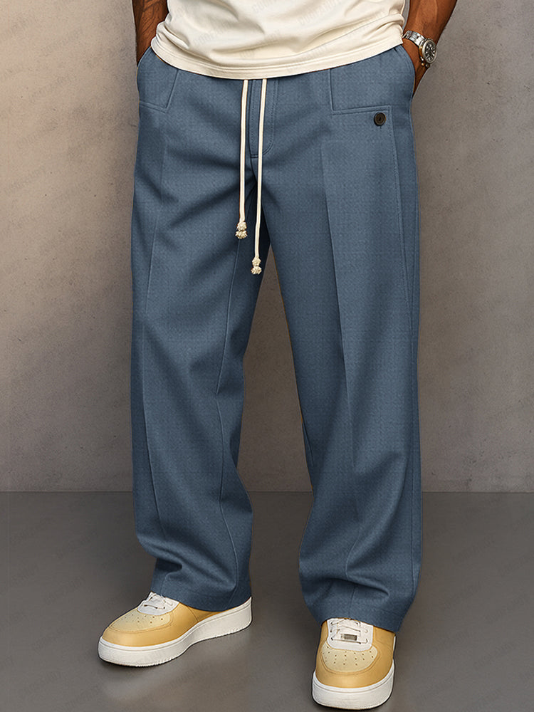 Front view of the wide-leg drawstring trousers in a muted blue, showing the cream cord and button pocket detail. 4