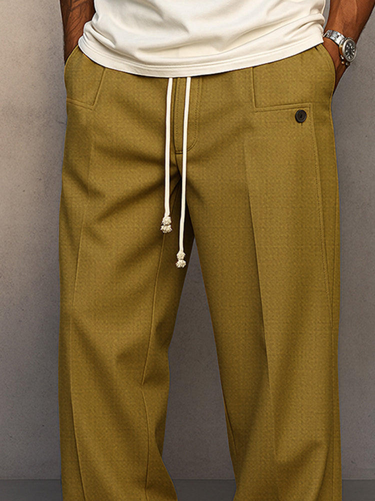 Close-up of the waist in mustard olive, showing the knotted cream drawcord, front pocket with button tab and pleat. 7