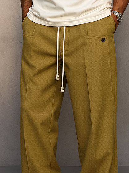 Close-up of the waist in mustard olive, showing the knotted cream drawcord, front pocket with button tab and pleat. 7