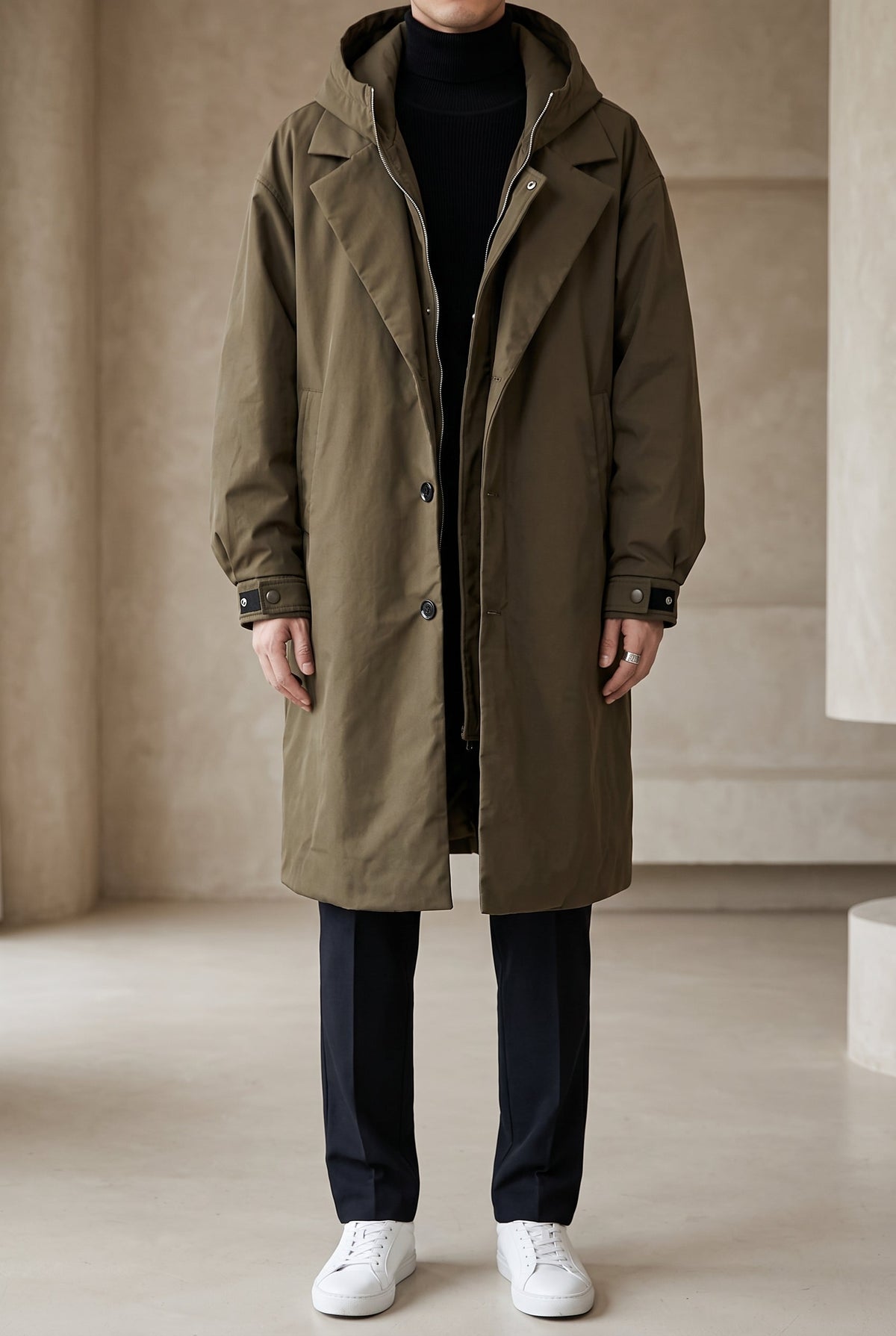 Olive-green hooded coat worn open by a model in a neutral studio, full-length front view 2