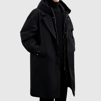 Black long hooded coat worn by a model, three-quarter view, with zip and buttons partly open 4