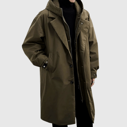 Olive-green long hooded coat worn by a model, three-quarter view, hand in pocket, over black polo neck 1