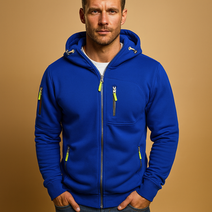 Model wearing the hoodie in bright royal blue with lime zip pulls and silver zips, standing against a tan backdrop. 3