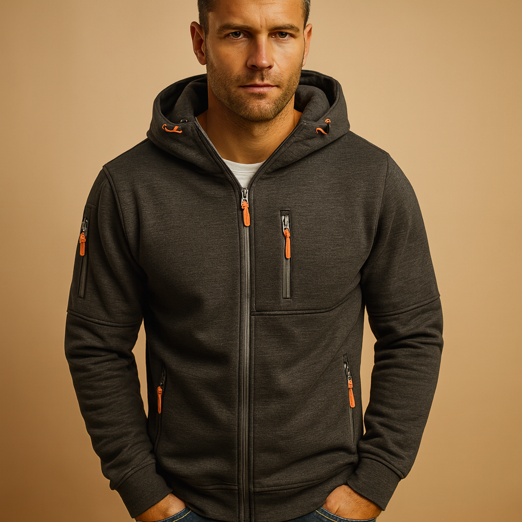 Model in the dark charcoal marl hoodie with orange zip pulls and hood drawcord ends, hands tucked into pockets. 4