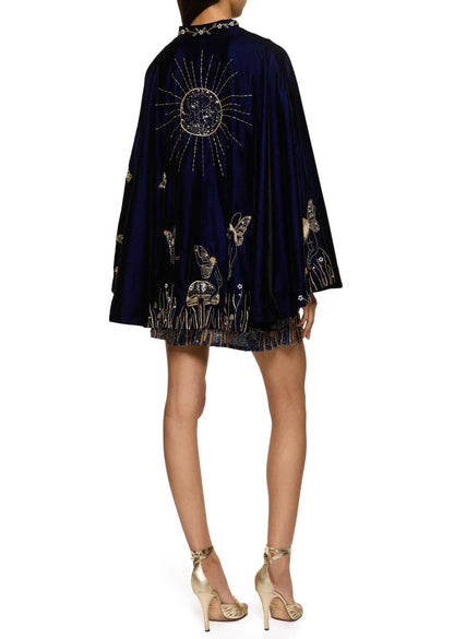 Back view of the navy velvet cape worn over the dress, with a large gold beaded sun 10