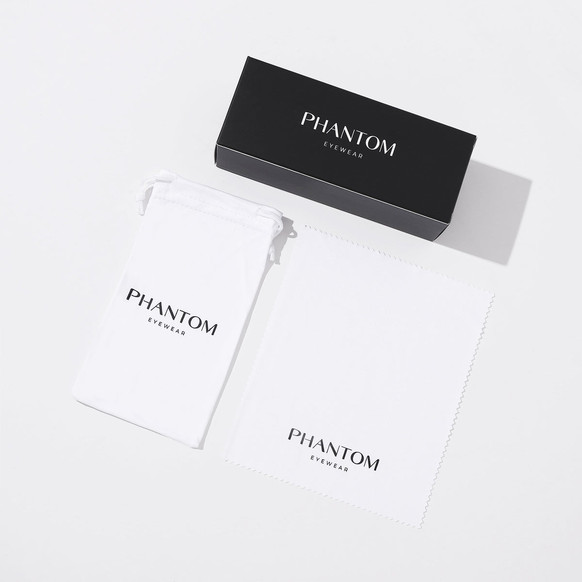 Flat lay of a black presentation box, a white drawstring pouch and a white cleaning cloth, all printed with branding. 7