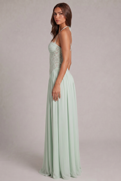 Side view of the mint green dress on a model glancing over her shoulder, showing the halter tie and lace bodice. 10