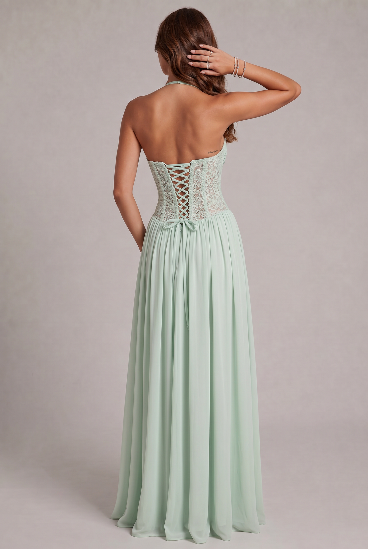 Back view of the mint green dress on a model, showing the lace-up corset back, bow and open back. 11