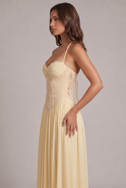 Side view of the pale yellow dress on a model, showing the lace corset panels, halter straps and gathered skirt. 7