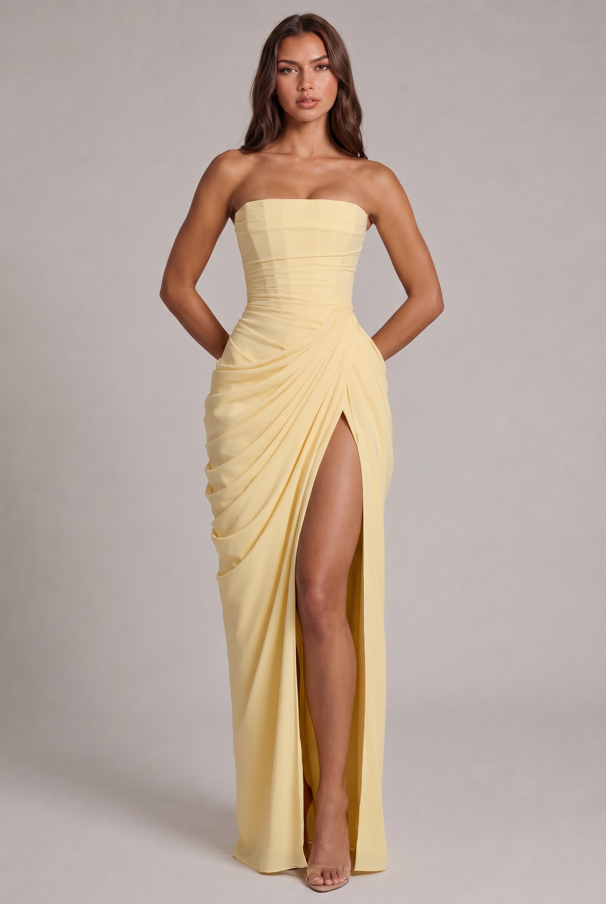 Model faces the camera in the pale yellow strapless gown, draped skirt and thigh-high slit 1