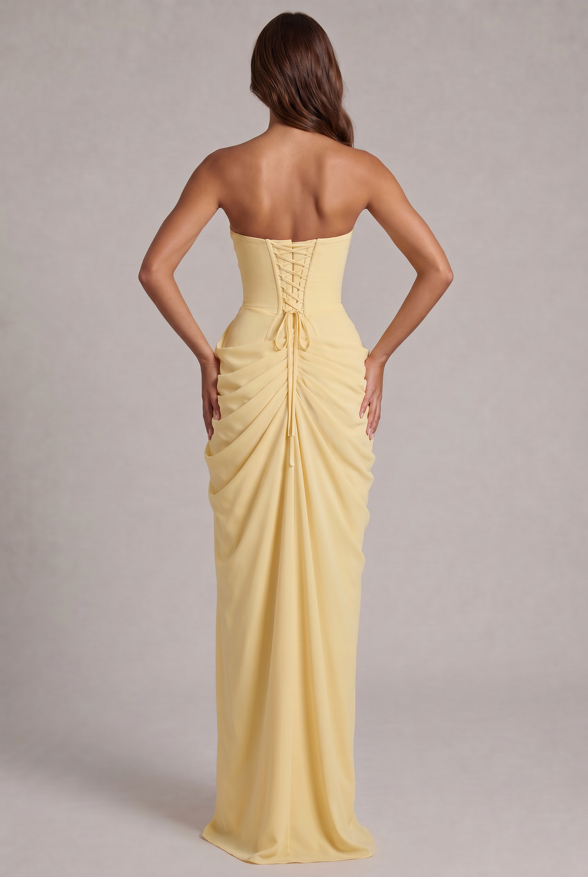 Back view of the pale yellow gown with lace-up corset back and gathered train 4