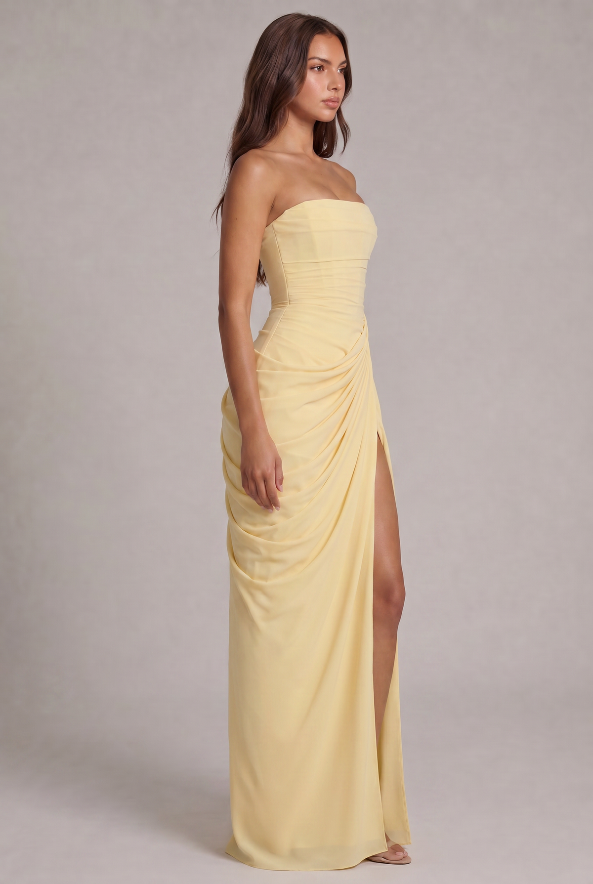 Side view of the pale yellow gown showing draped wrap skirt and high slit 3