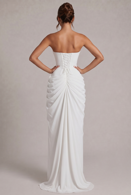Back view of the white gown with lace-up corset, hair in a bun, gathered train 20