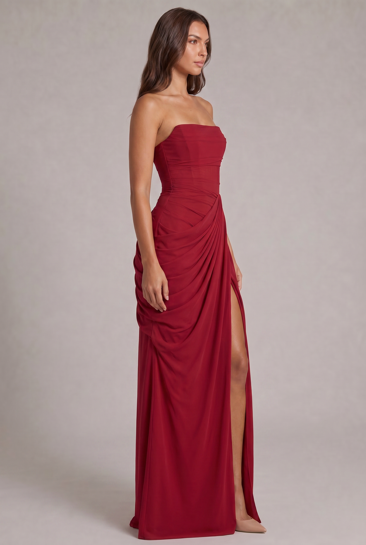 Red strapless maxi dress seen from the side, showing the gathered hip drape and leg slit 23