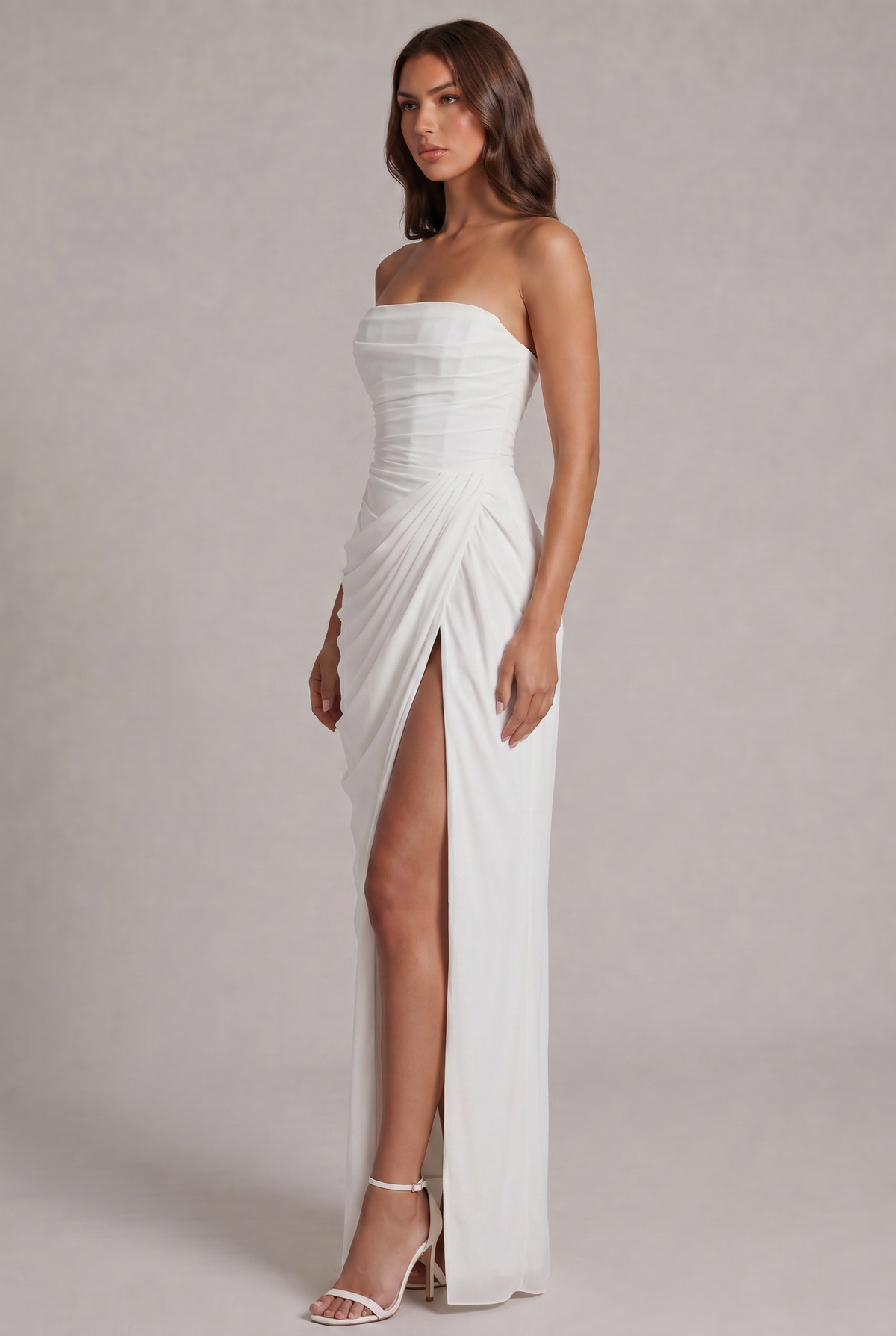 Angled side view of the white gown showing pleated wrap detail and high slit 19