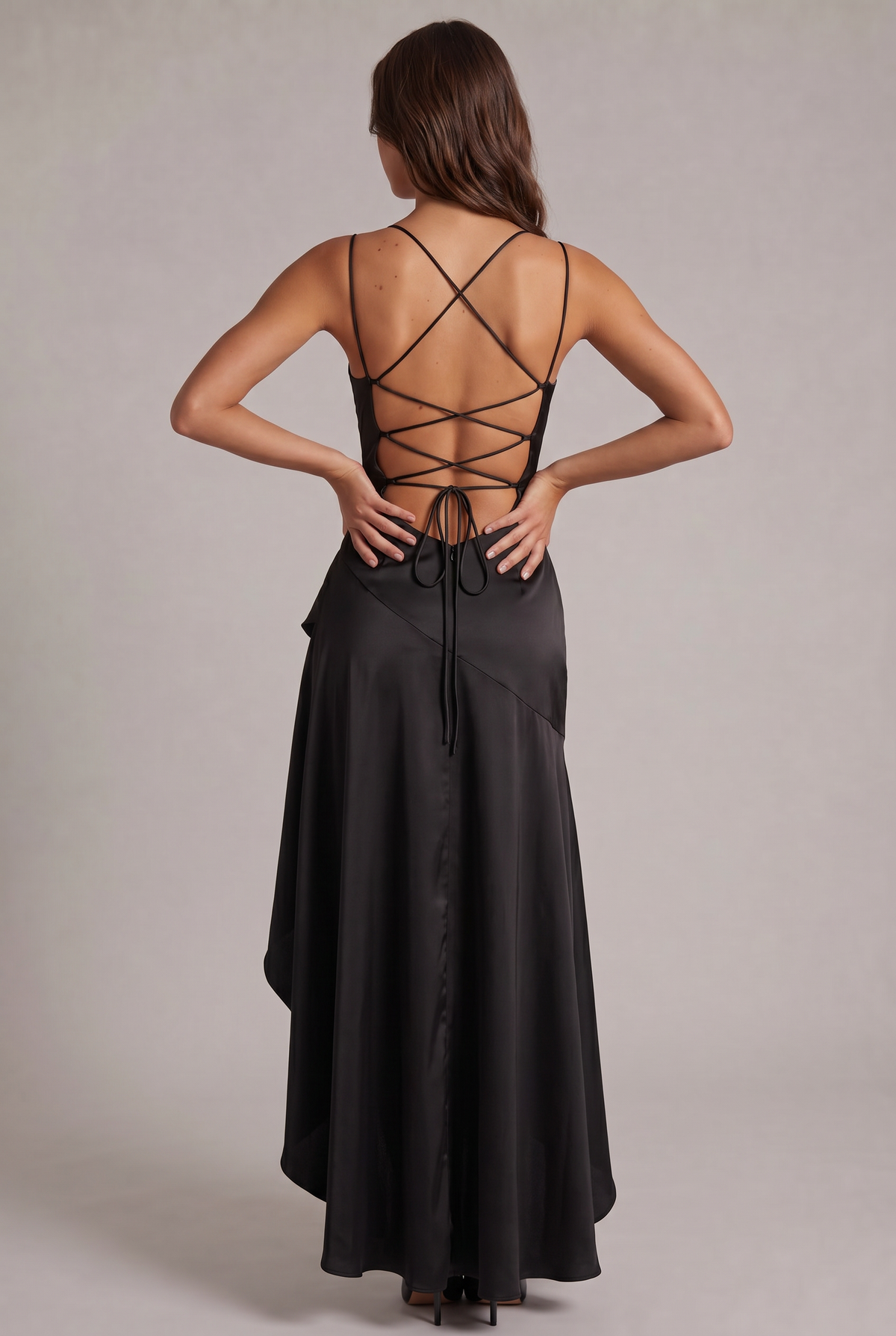Back of the black satin dress showing criss-cross lace-up straps, bow tie and long flowing skirt 12