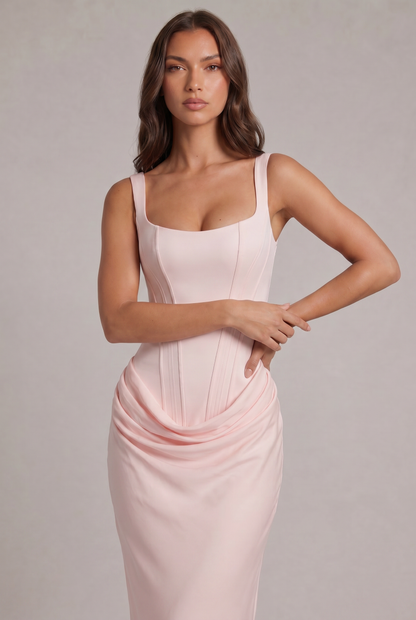 Close-up of the pale pink dress on a model, showing the seamed corset bodice, wide straps and softly draped waist. 26