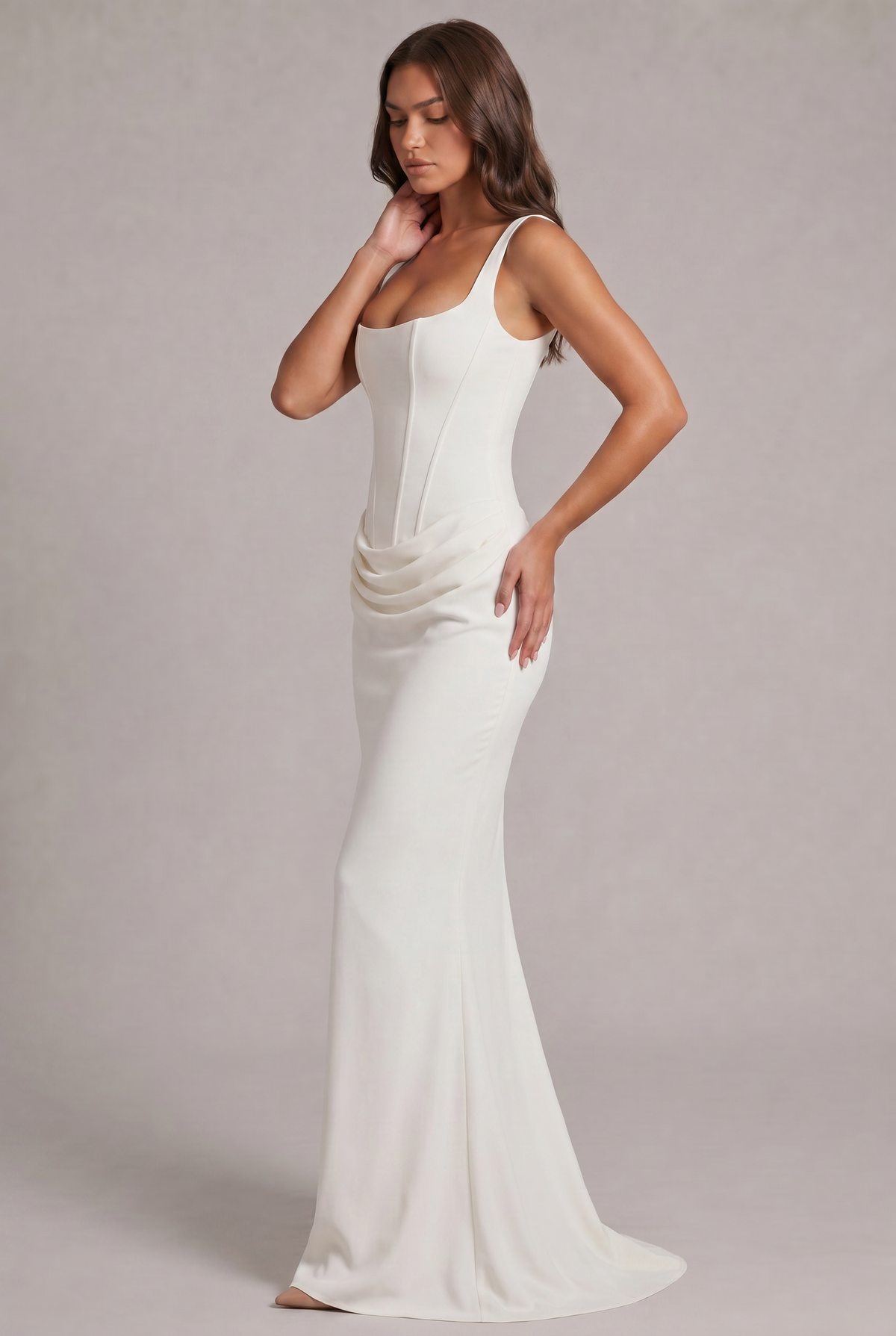 Side view of the white maxi dress, showing the corset bodice, the draped hip detail and the skirt flaring into a small train. 7