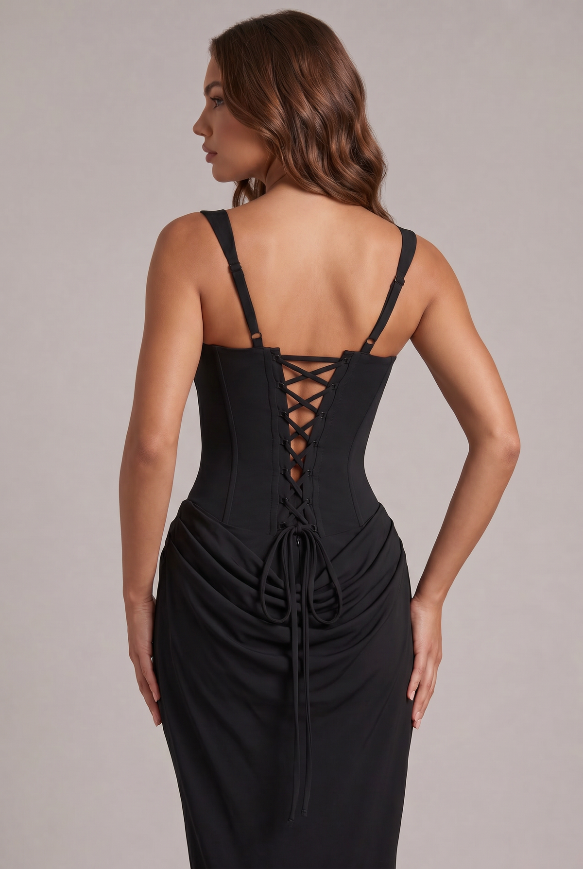 Close-up of the black dress back, showing the lace-up corset closure, adjustable straps and long ties over the draped skirt. 12