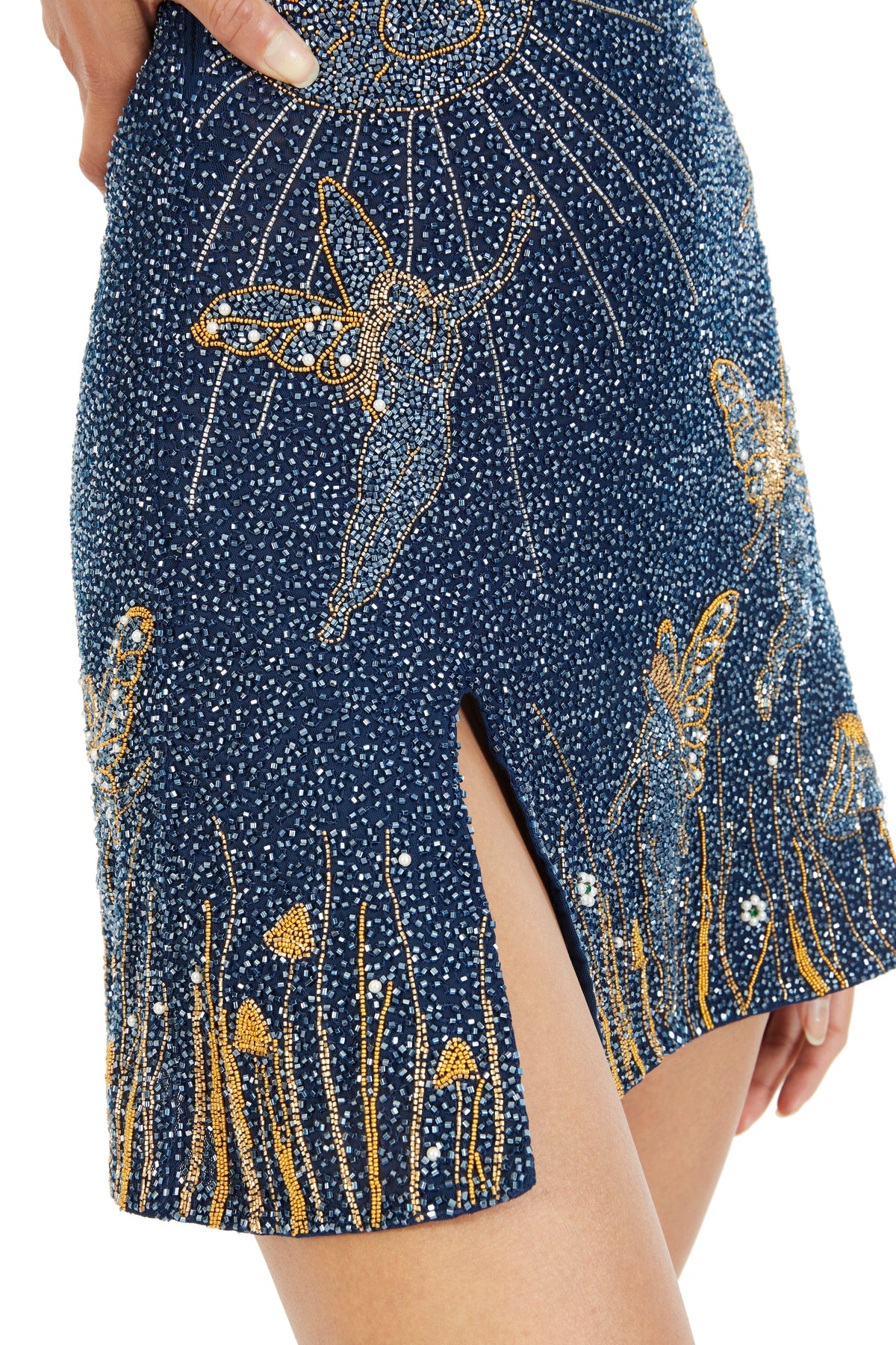 Close-up of the skirt's dense blue beadwork, with gold fairies, mushrooms, grasses and a small side slit 4