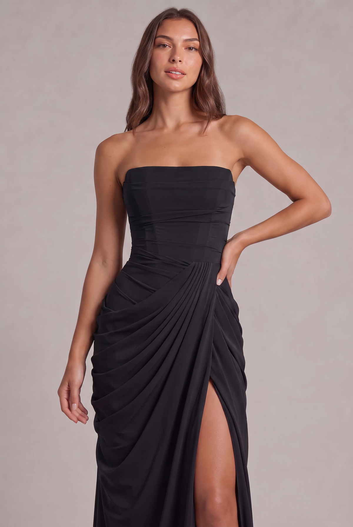Close-up of the black dress's structured bodice and pleated wrap drape at the waist 26