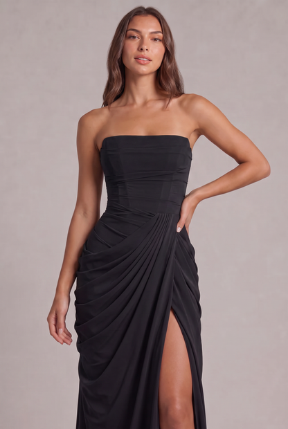 Close-up of the black dress's structured bodice and pleated wrap drape at the waist 26