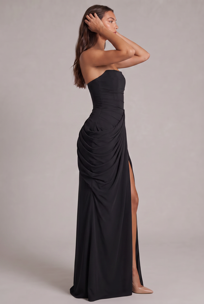 Black strapless maxi dress in side profile, model's hands in her hair, slit visible 27