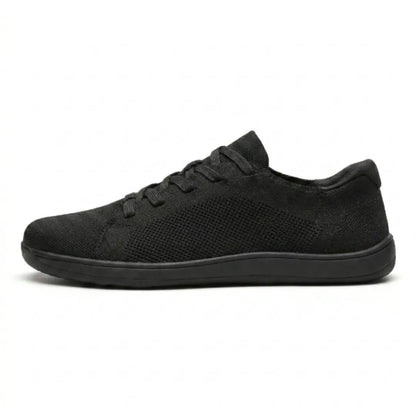 Side view of an all-black knit lace-up trainer with a mesh panel and a flat black sole. 10