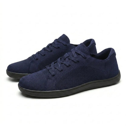 Pair of navy mesh lace-up trainers with flat black soles, angled three-quarter view on a plain background. 25