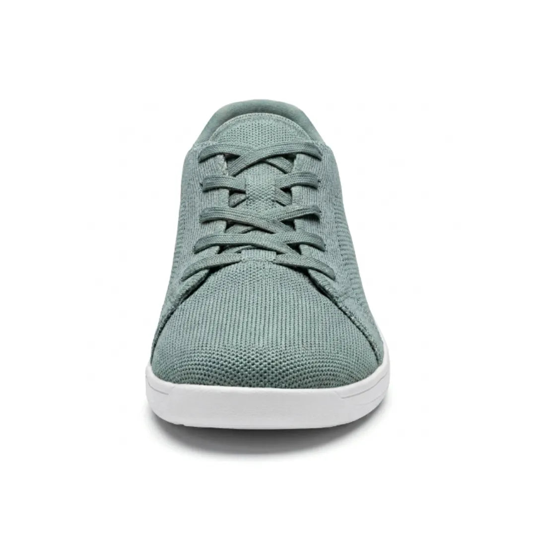 Sage green knit trainer seen from the front, showing criss-cross laces, rounded toe and flat white sole. 35