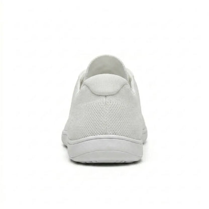 Rear view of a white knitted trainer showing the heel tab, textured mesh upper and thin flat sole. 45