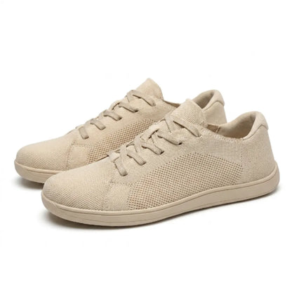 Pair of beige knit lace-up trainers at an angle, showing the perforated mesh side panels and the thin flat sole. 7