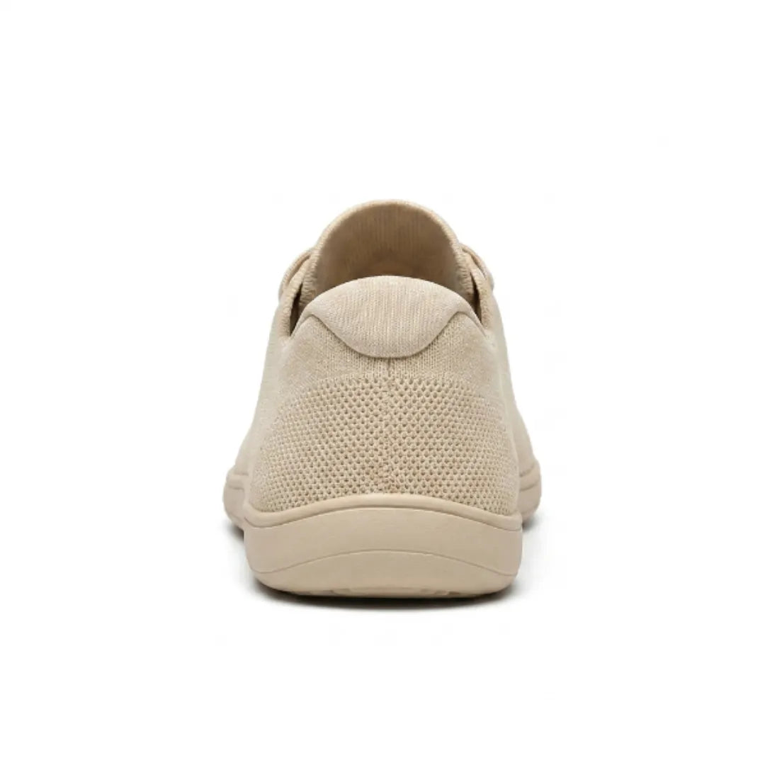 Rear view of a beige knit trainer showing the padded heel collar, mesh heel panel and flat sole. 9