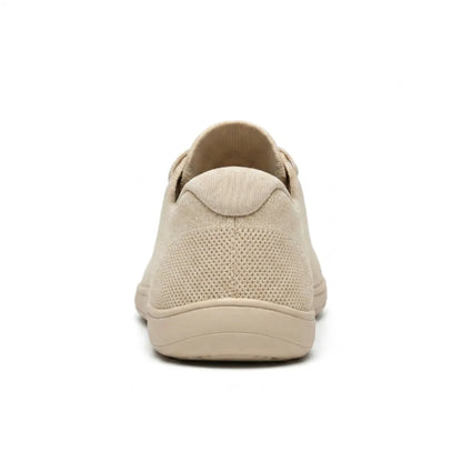 Rear view of a beige knit trainer showing the padded heel collar, mesh heel panel and flat sole. 9