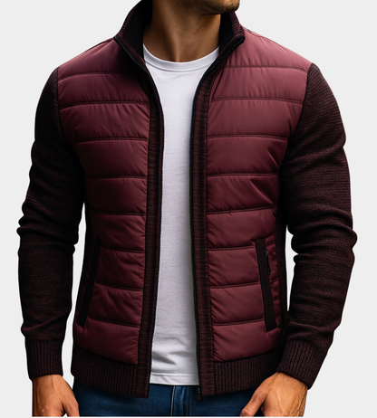 Man wearing the quilted jacket in burgundy with dark knitted sleeves and zipped side pockets, open over a white t-shirt. 3