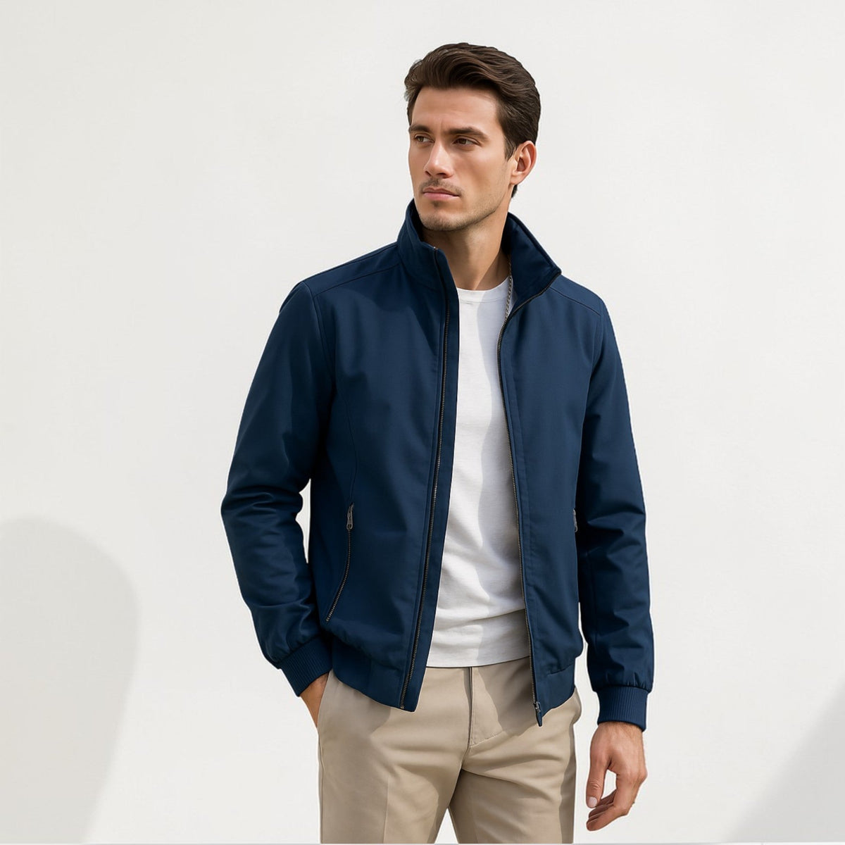 Model wearing the zip-up bomber jacket in navy over a white t-shirt and beige chinos, with ribbed cuffs and hem. 1