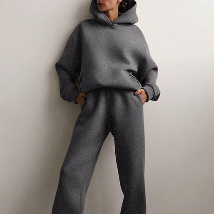 Model standing with hands in the pockets of the dark grey marl hoodie and straight-leg joggers, hood up. 3