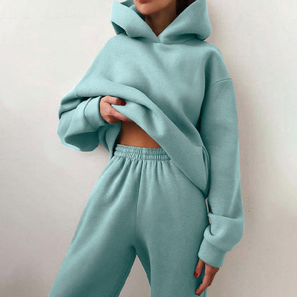 Model in the soft aqua hoodie and elastic-waist joggers, holding the hem of the oversized top with one hand. 7