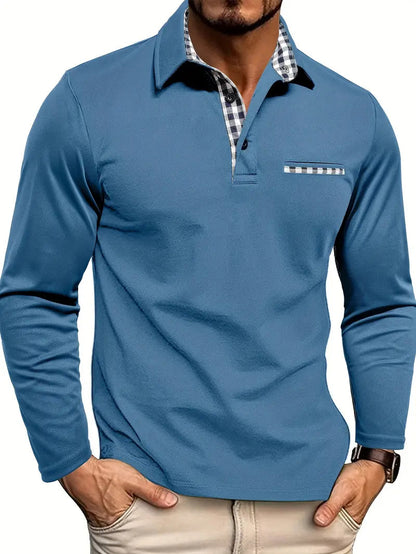 Man wearing the polo in steel blue, with black and white gingham trim on the collar, placket and chest pocket, hands in beige trousers. 4