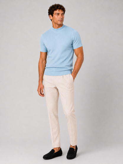Full-length studio shot of the light blue top with cream trousers and black suede loafers. 9
