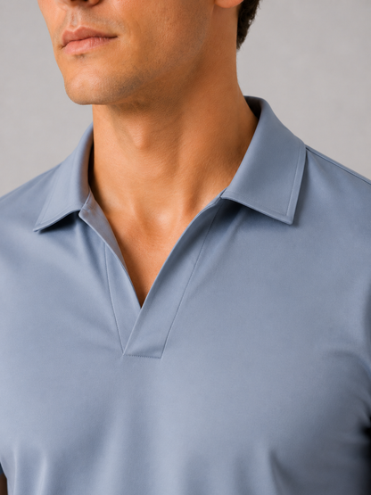 Close-up of the dusty blue polo's open V-neck collar and placket, showing the smooth fabric and clean stitching. 17