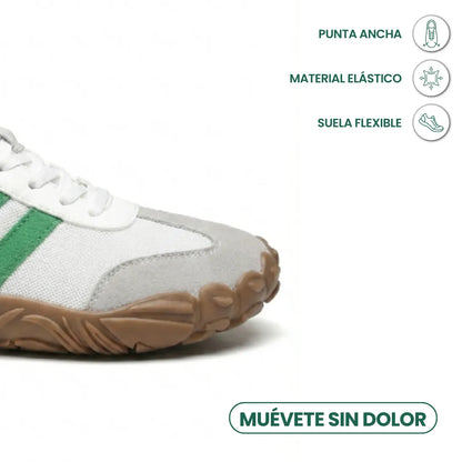 Close-up of the wide rounded toe of the white shoe with grey toe cap, with icons for toe room, stretch and flexibility. 32