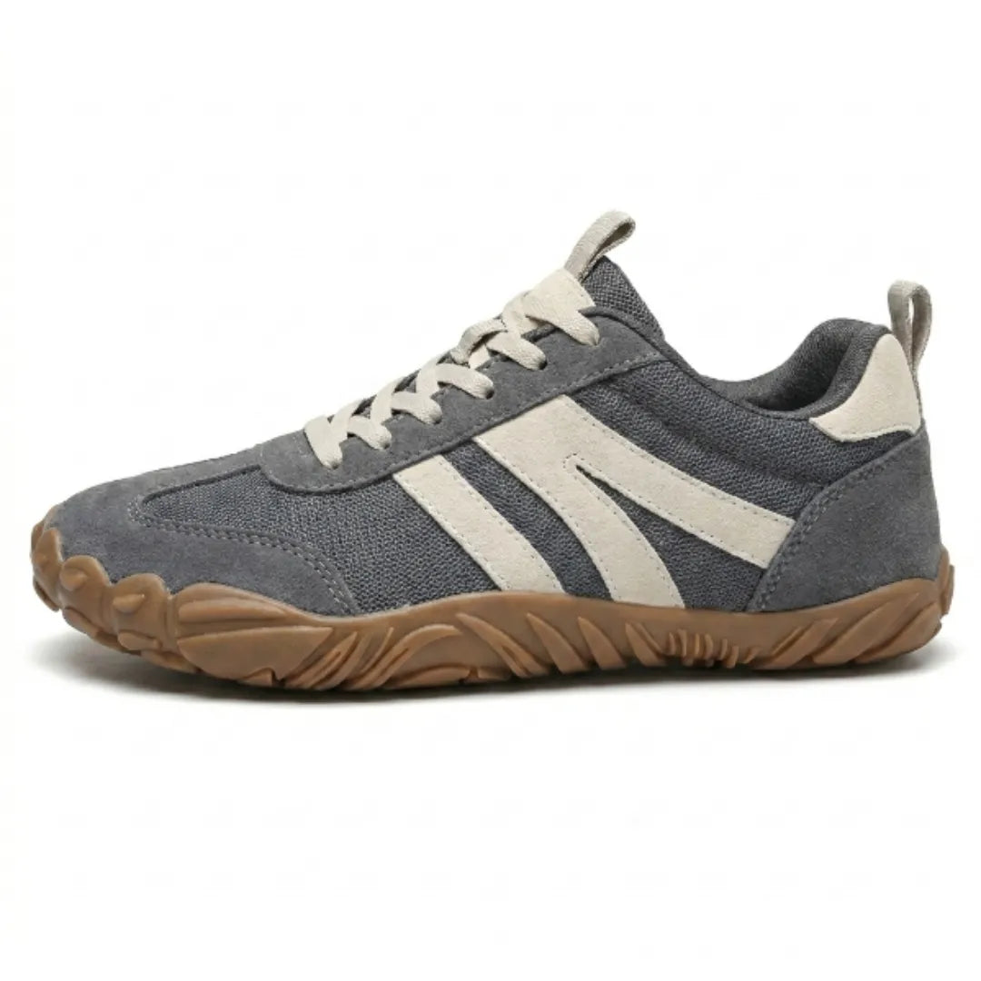 Side view of a grey mesh and suede barefoot shoe with cream stripes, laces and a flexible tan rubber sole. 1
