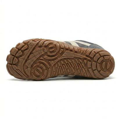 Underside of the grey shoe showing the tan rubber outsole with its textured grip pattern. 9