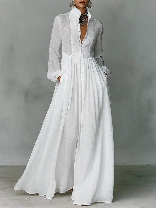 Cropped from the neck down, a model wears the white buttoned dress with hands in pockets 1