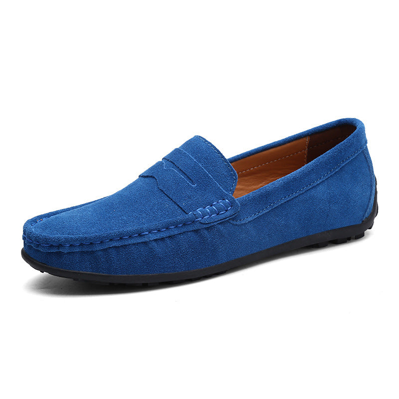 Royal blue suede penny loafer shown from the front three-quarter angle, with stitched moccasin toe and black grip sole. 6