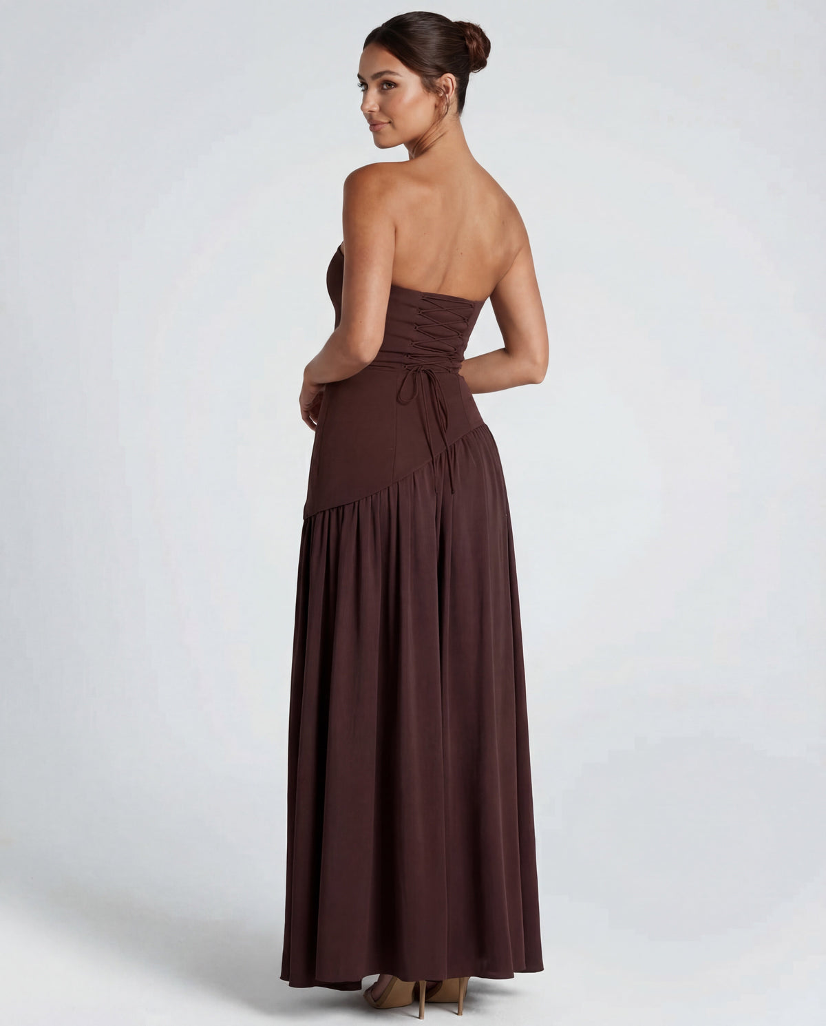 Back view of brown strapless maxi dress showing corset-style lace-up back, gathered skirt and asymmetric waistline 2
